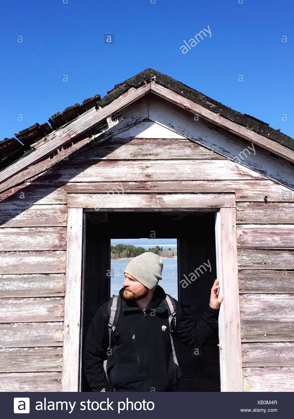 Homme debout à la porte du chalet Banque D'Images