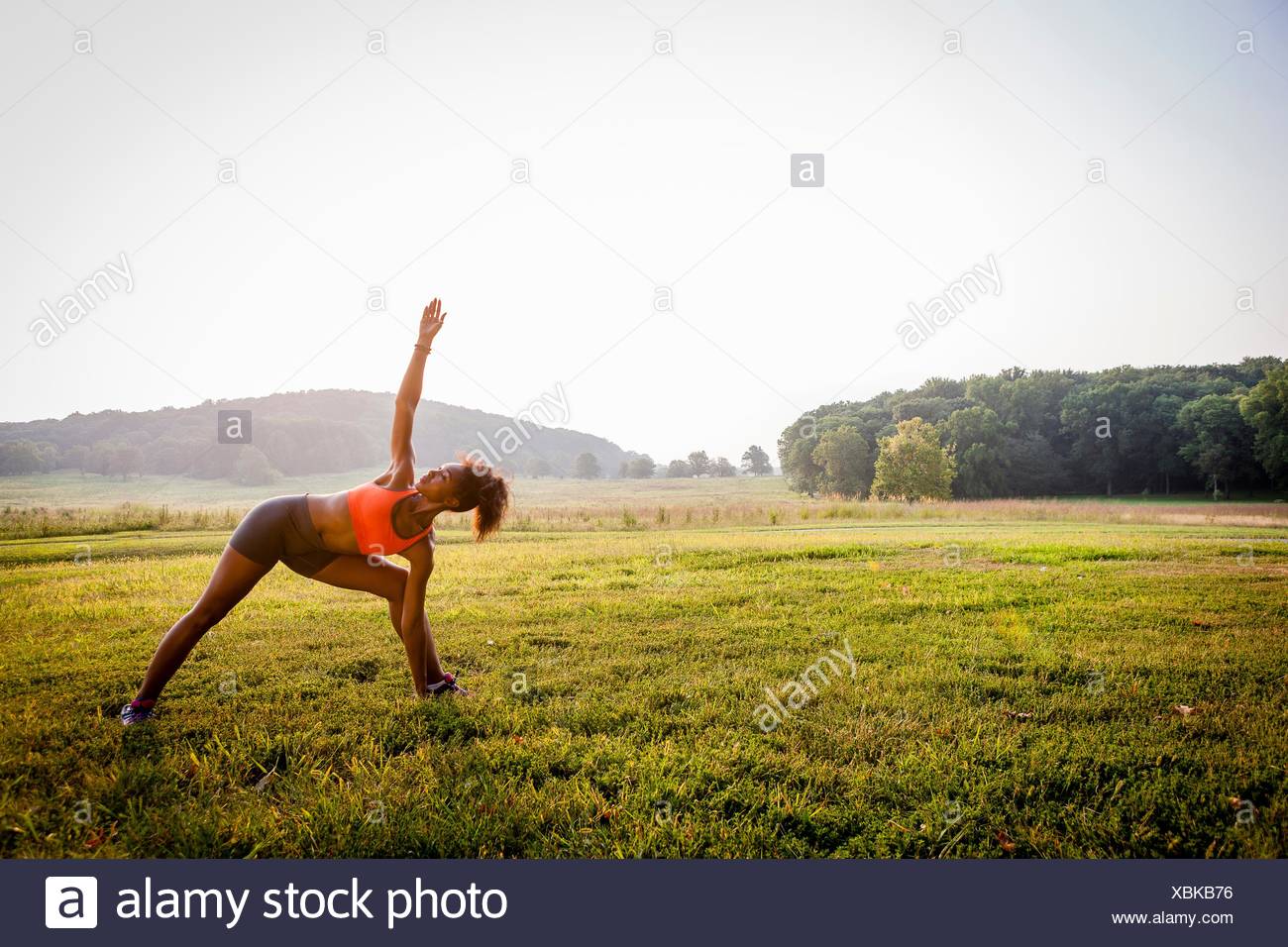 Young woman practicing yoga in rural park Banque D'Images