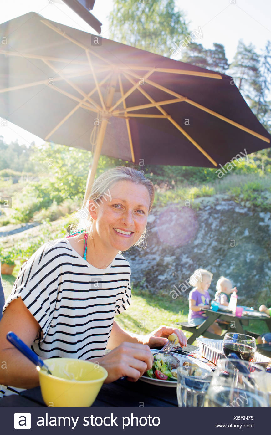 A smiling woman eating outdoors Banque D'Images
