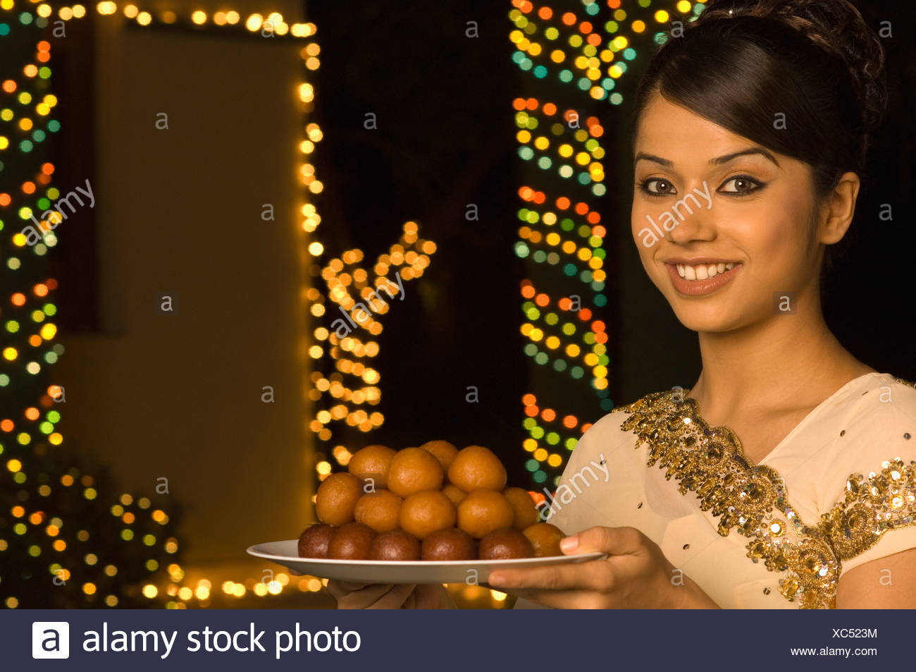 Woman holding bonbons dans une assiette et smiling Banque D'Images