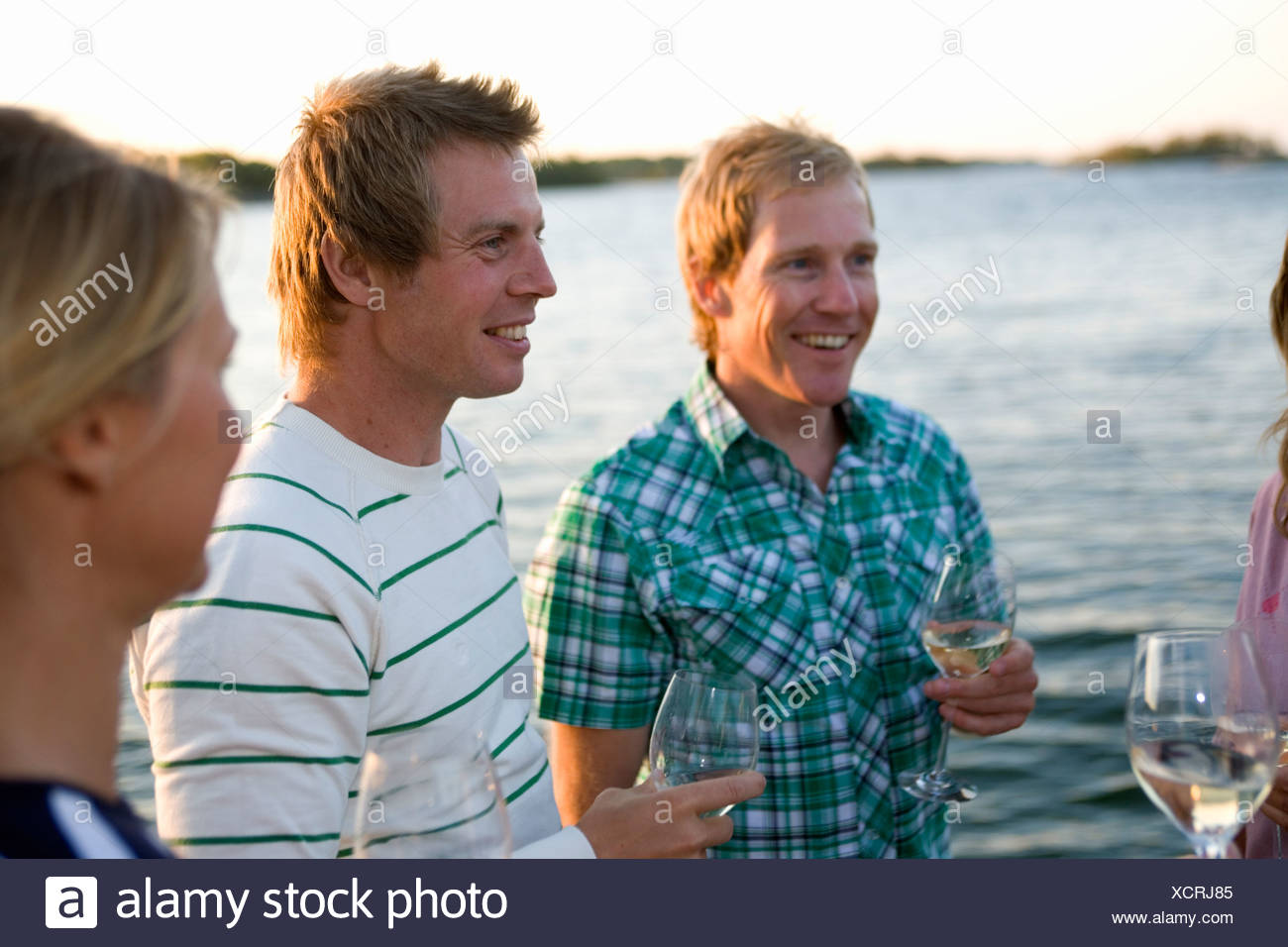 Trois personnes rire et boire, Fejan, archipel de Stockholm, Suède. Banque D'Images