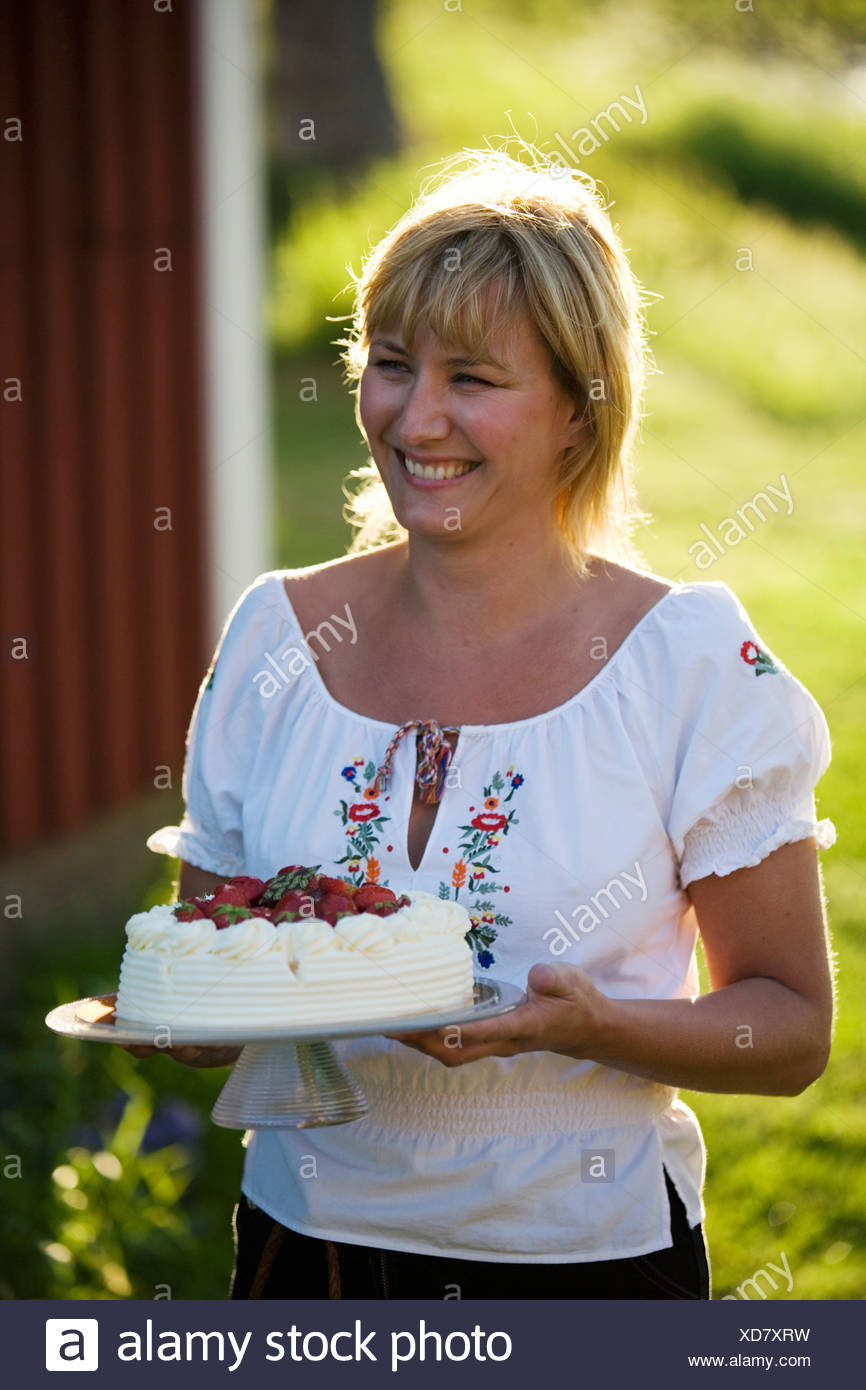 Une femme et un gâteau aux fraises, Fejan, archipel de Stockholm, Suède. Banque D'Images
