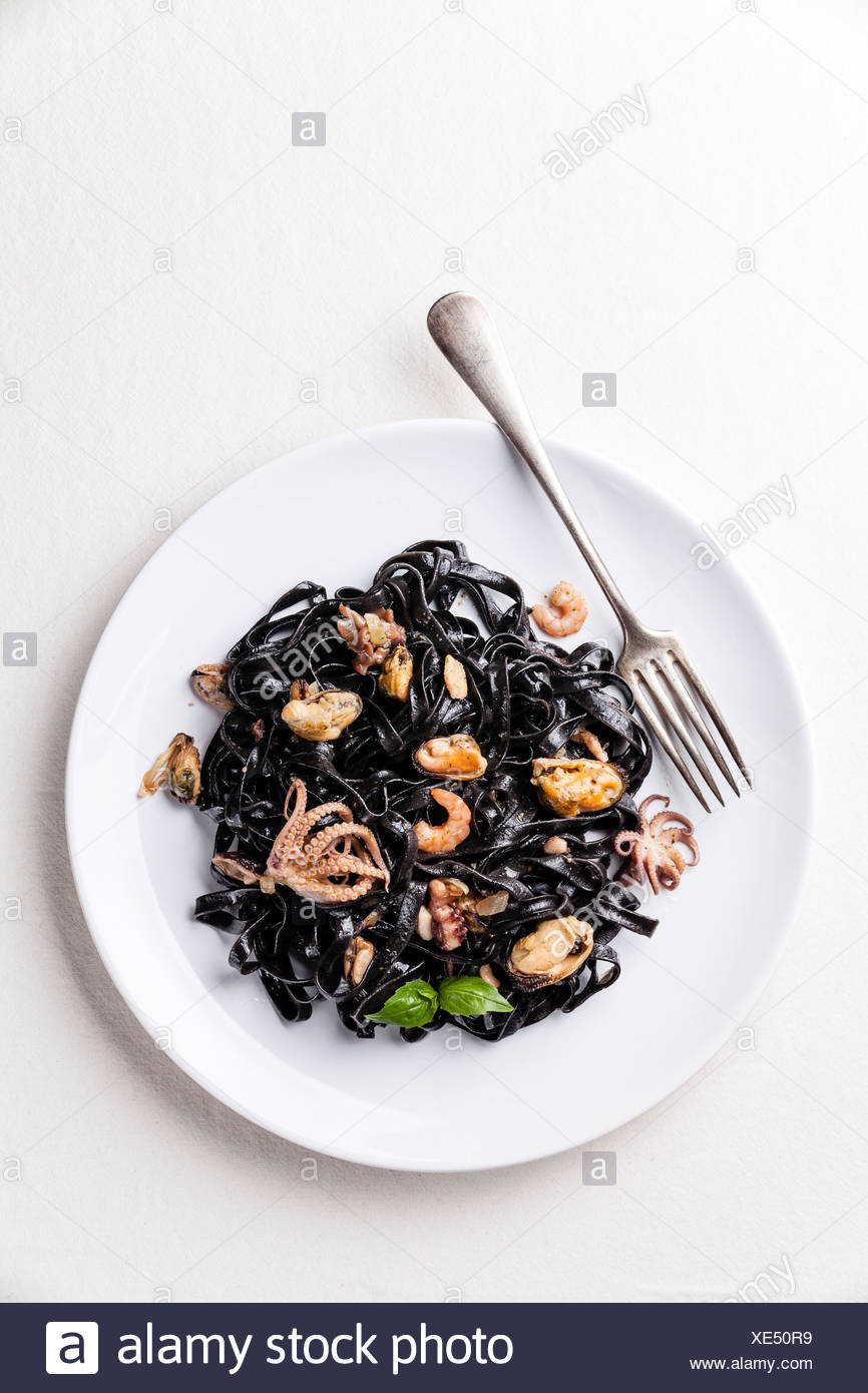 Les pâtes noires avec des fruits de mer sur plaque blanche Banque D'Images