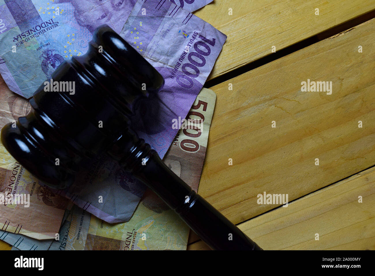 Giudici nero martello e Rupiah indonesiano sulla scrivania in legno. Il concetto di legge Foto Stock