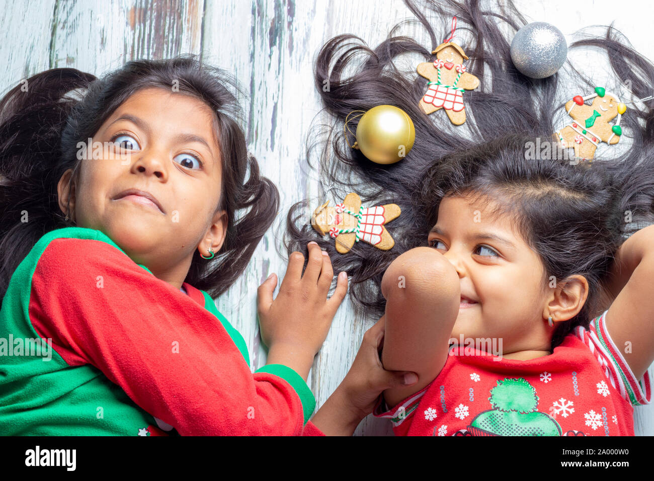 Sorridente sorelle decorare i loro capelli con decorazioni di Natale Foto Stock