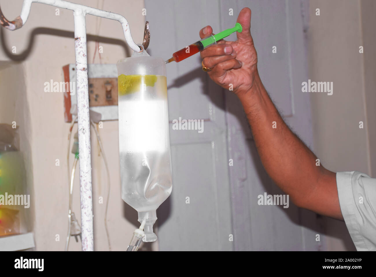 Versando la medicina nella bottiglia con una siringa del medico mano trattiene una siringa e una bottiglia per infusione in ospedale. Salute e concetti medici Foto Stock