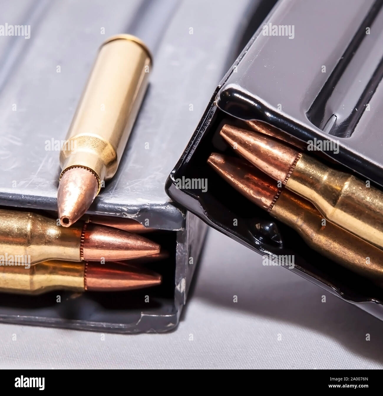 Due fucile caricato riviste con un calibro 223 bullet sulla sommità di uno di loro su uno sfondo bianco Foto Stock