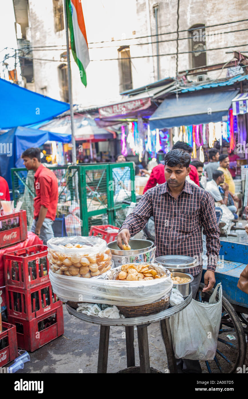 Un uomo di vendere un snack indiano, Pani Puri, a Chandni Chowk mercato su un tardo pomeriggio Foto Stock