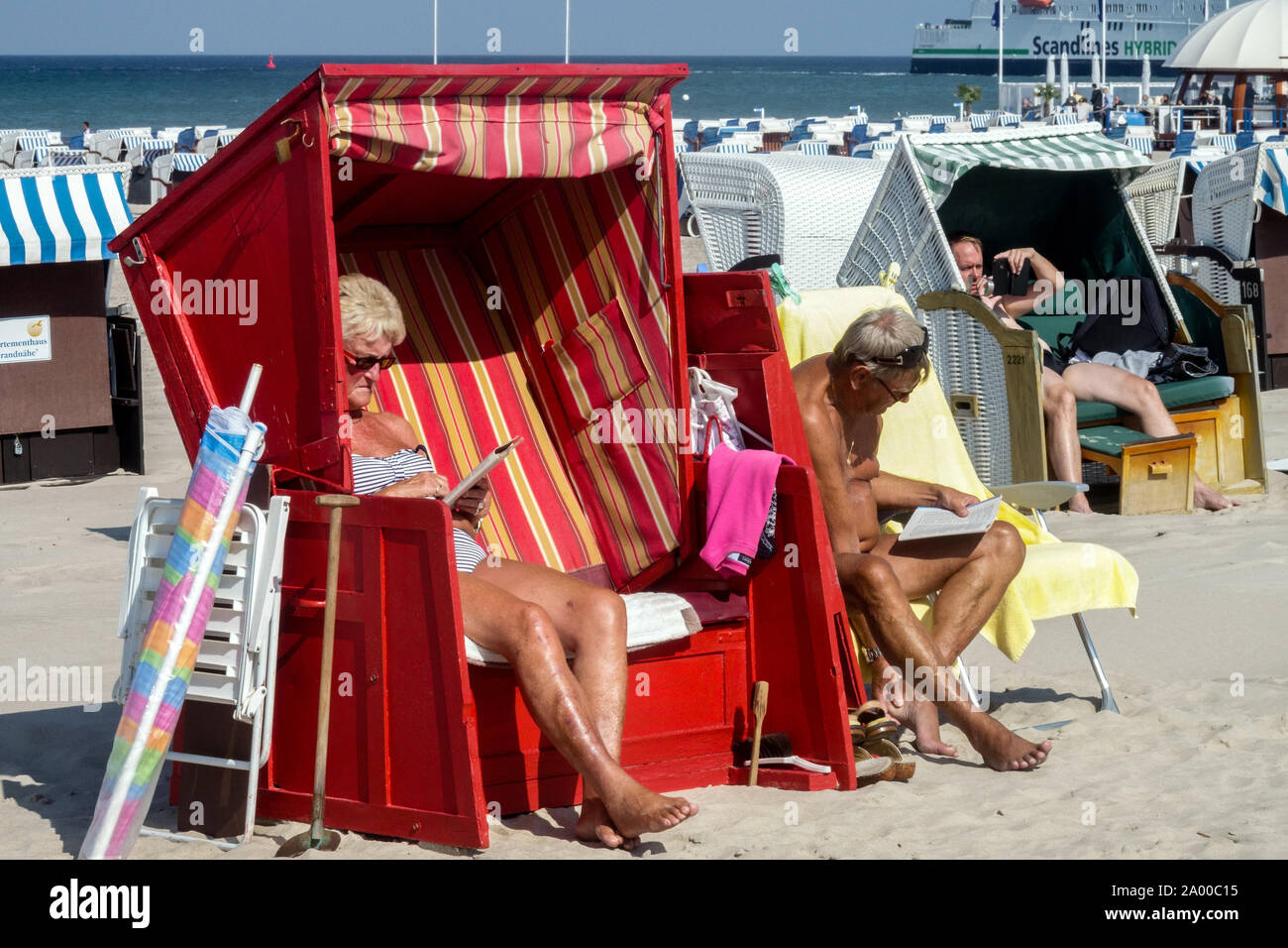 Anziani, la gente tedesca vacanza su una spiaggia del Mar Baltico Vacanze estive Germania Warnemunde strandkorb Foto Stock