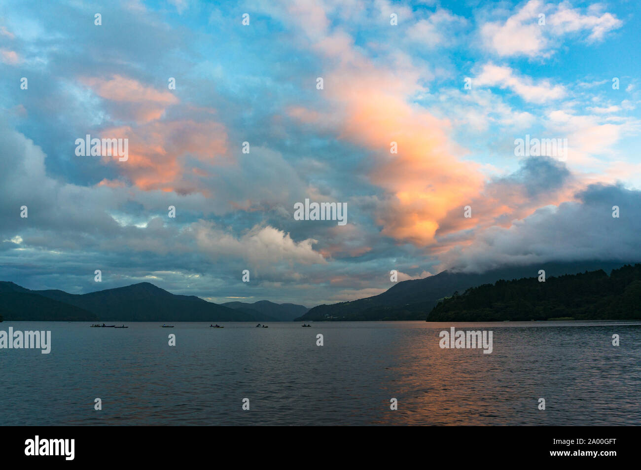 Lago di montagna, caldera gli orari di alba e tramonto con barche da pesca nella distanza. Lago Ashi, Hakone, Giappone Foto Stock