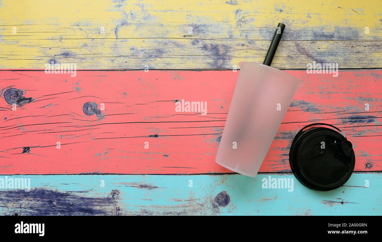 Piatto di laici una semi-trasparenti monouso per bevande da asporto cup con paglia e un coperchio staccato. Foto Stock