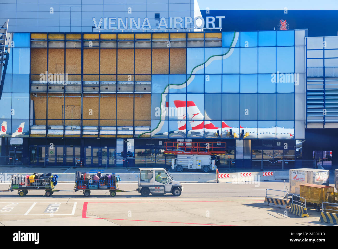 Schwechat, Austria - 15 Settembre 2019: l'Aeroporto Internazionale di Vienna / Flughafen Wien (VIE) - edificio principale con finestre di vetro, un'Austrian Airlines Foto Stock