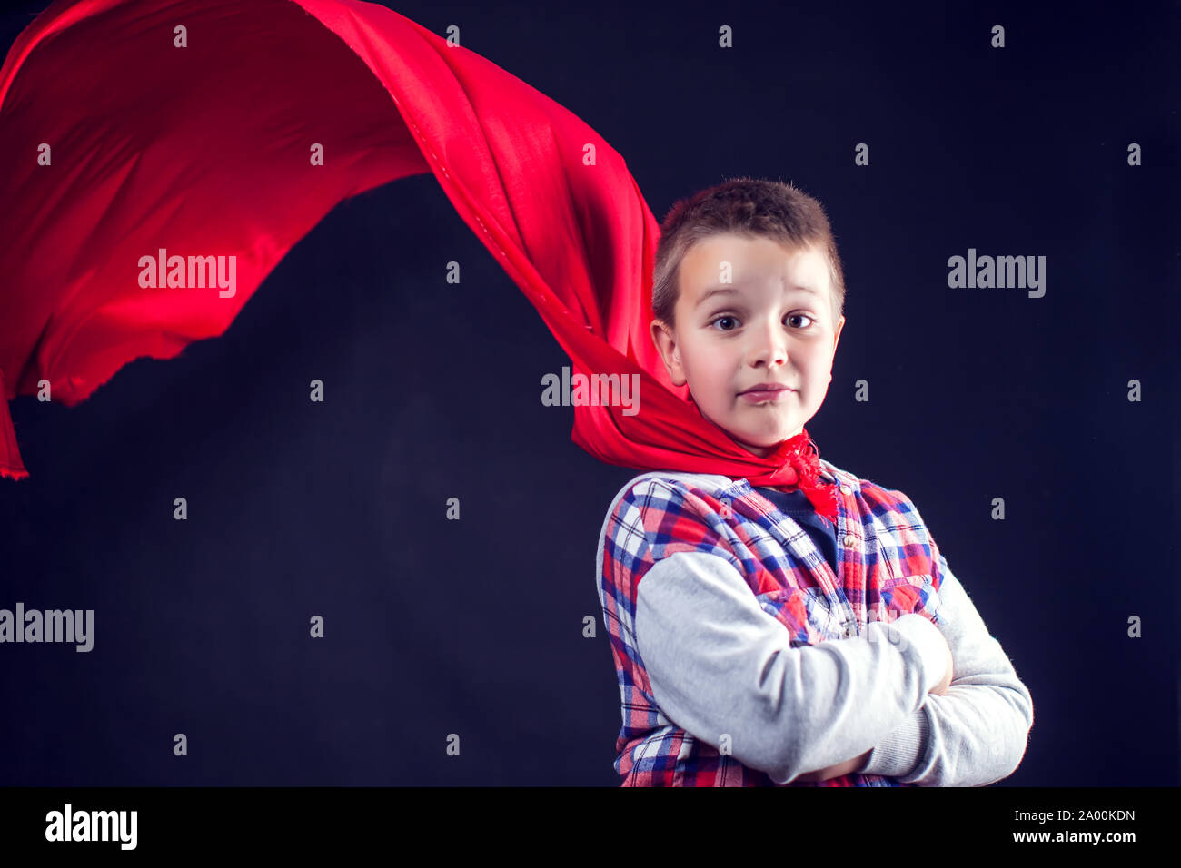Un simpatico ragazzo con mantello rosso come un supereroe. I bambini e il concetto di successo Foto Stock