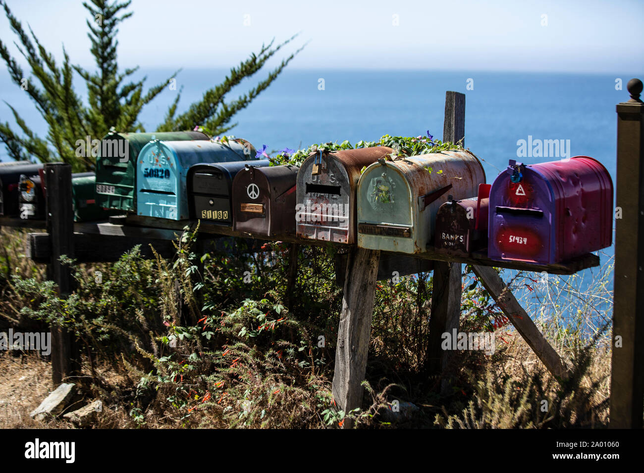 Knallbunte Briefkästen stehen am autostrada nr. 1 in Kalifornien, im Hintergrund der pazifische Ozean. Der autostrada ist hier im Bereich Big Sur eine traum Foto Stock