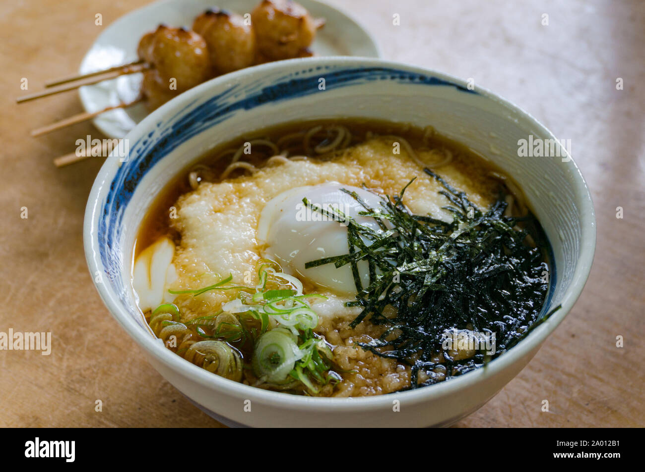 In tradizionale stile giapponese ramen, soba noodle soup con polpette di riso su un bastone e il tè verde sullo sfondo Foto Stock
