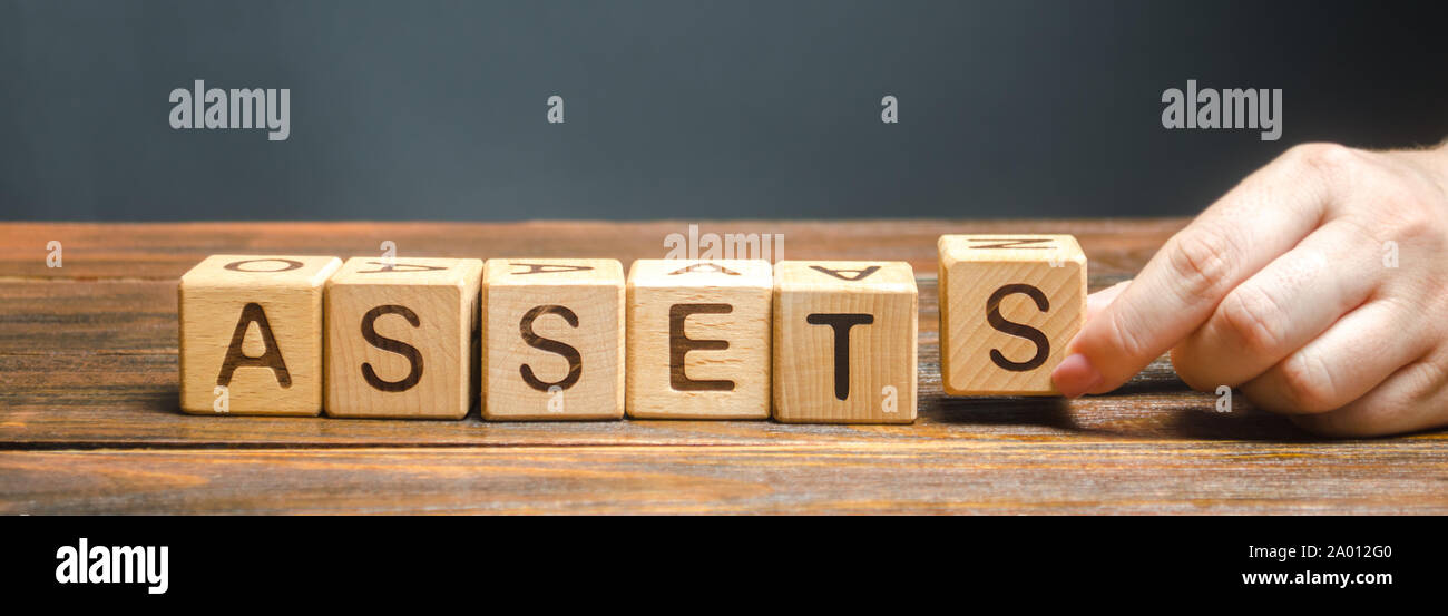 Blocchi di legno con la parola attivi e diffusa in maniera casuale i cubi. La risorsa di proprietà dell'azienda. La contabilità finanziaria. Denaro e finanze. Equival contanti Foto Stock