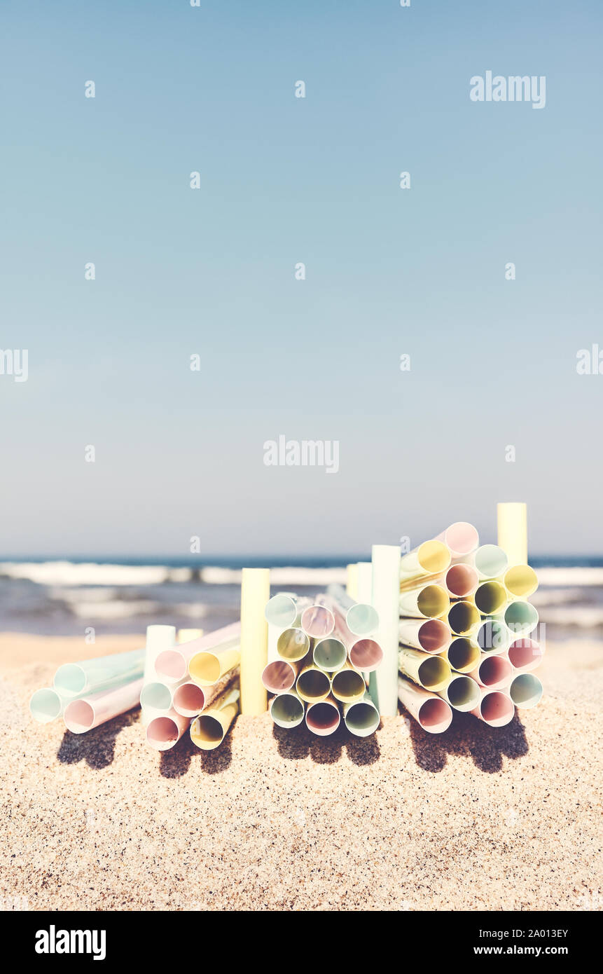 Pile di cannucce di plastica su una spiaggia, plastica inquinamento ambientale concetto, il fuoco selettivo, tonificazione del colore applicato. Foto Stock