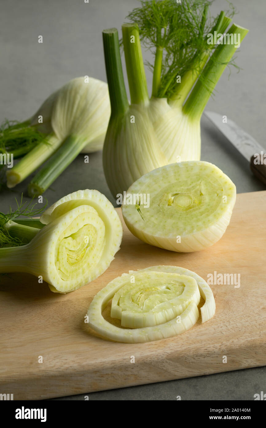 Crudo fresco organici di finocchio e le fette su un tagliere Foto Stock