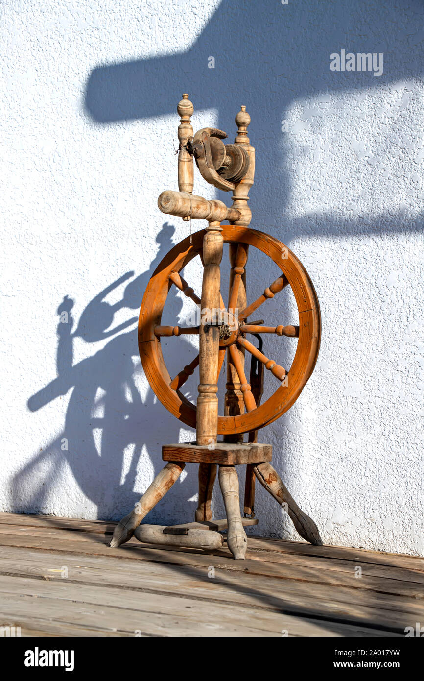 Legno ruota di filatura al sole del mattino contro un muro bianco closeup Foto Stock