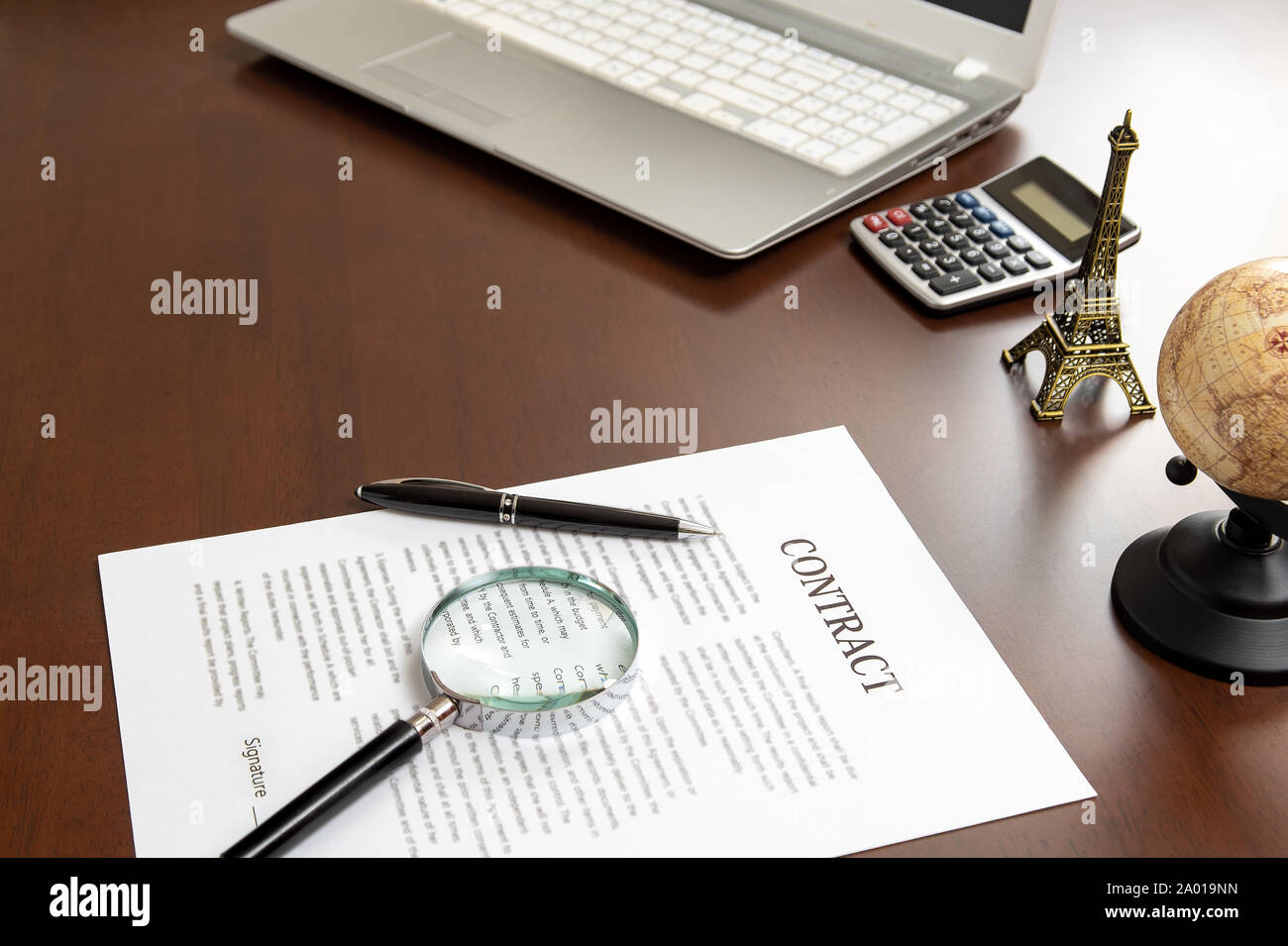 Documenti e lenti d'ingrandimento contract sulla scrivania di un uomo d'affari Foto Stock