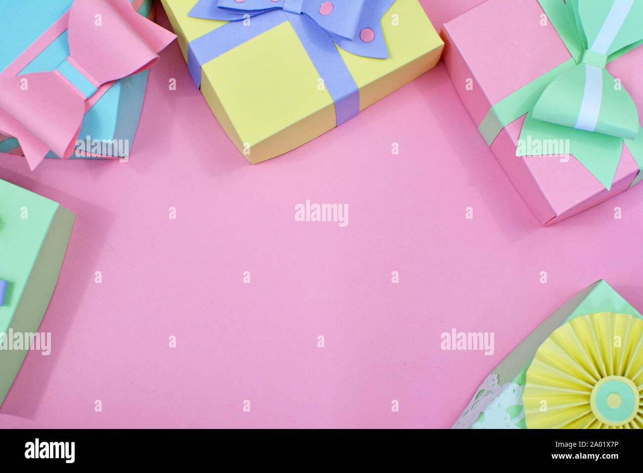 Appartamento laici con sfondo color pastello carta artigianale confezioni regalo con nastri framing copia dello spazio nel centro di sfondo rosa Foto Stock
