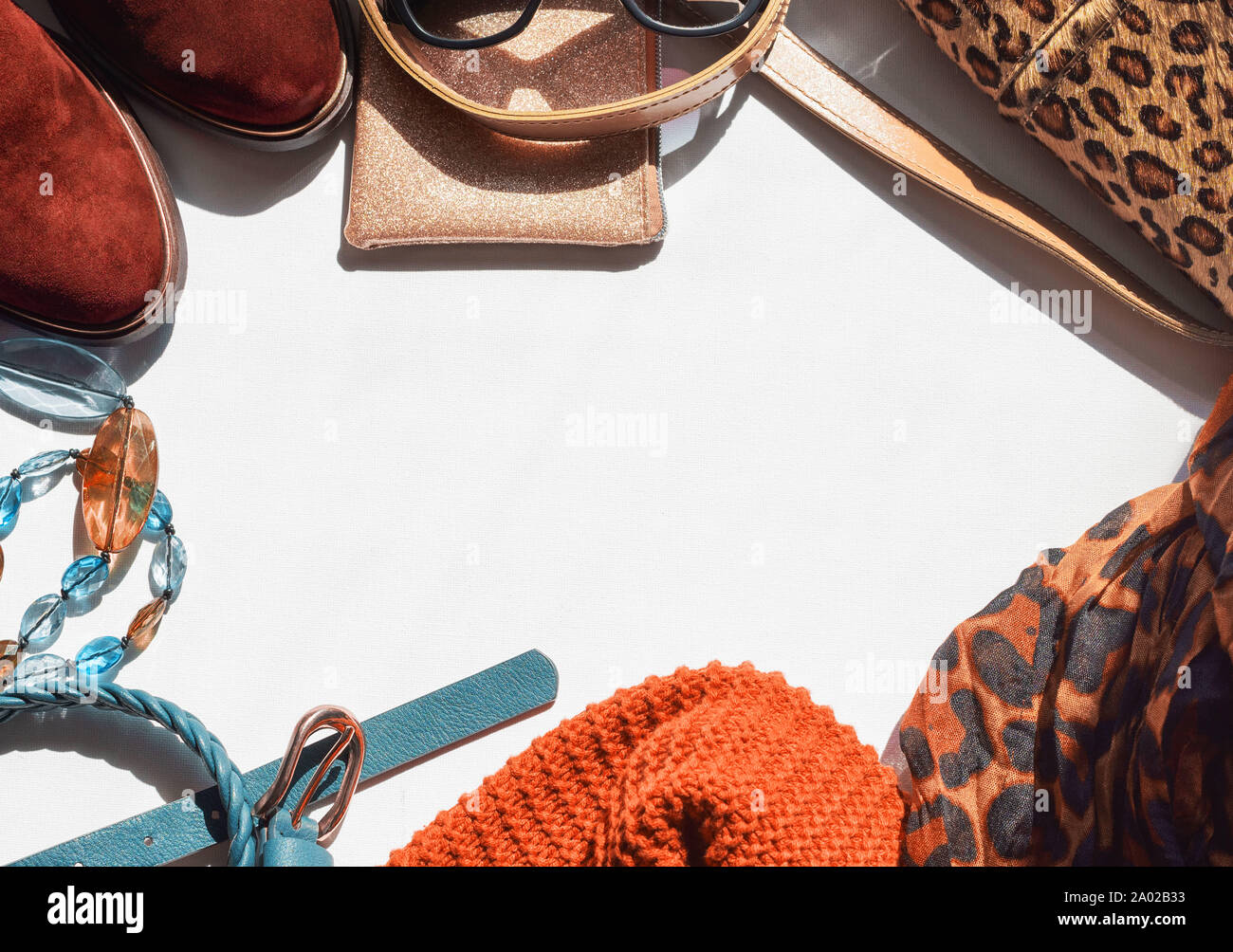 Donna Accessori leggera lavorata a maglia Sciarpa Snood cinghia su uno sfondo bianco. chelsea stivali occhiali da sole borsetta. Spazio di copia, laici piatta Foto Stock