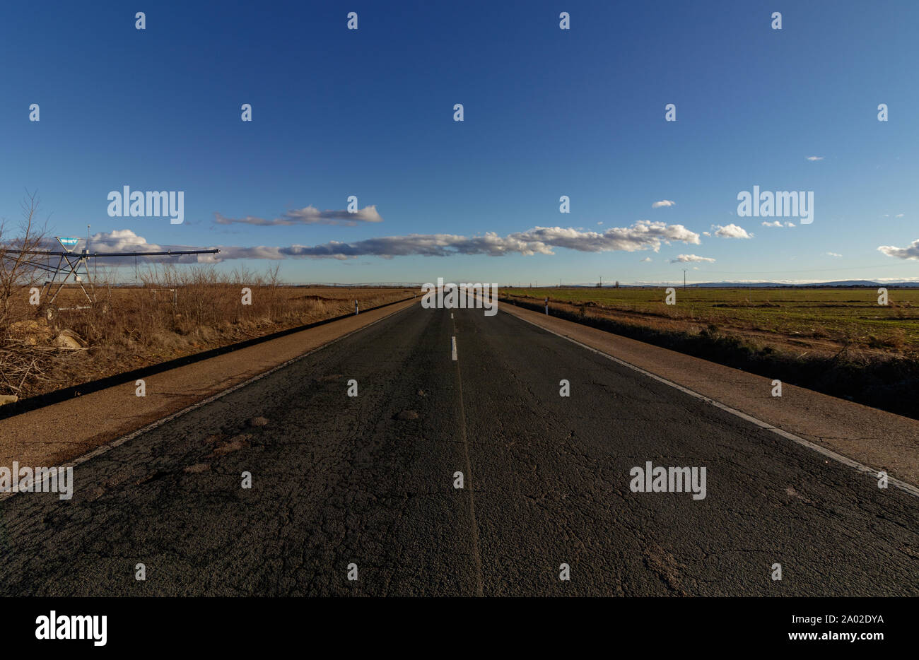 Lunga strada diritta tra i campi in Spagna Foto Stock