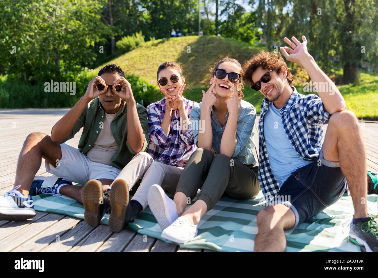 Happy amici rendendo volti al summer park Foto Stock