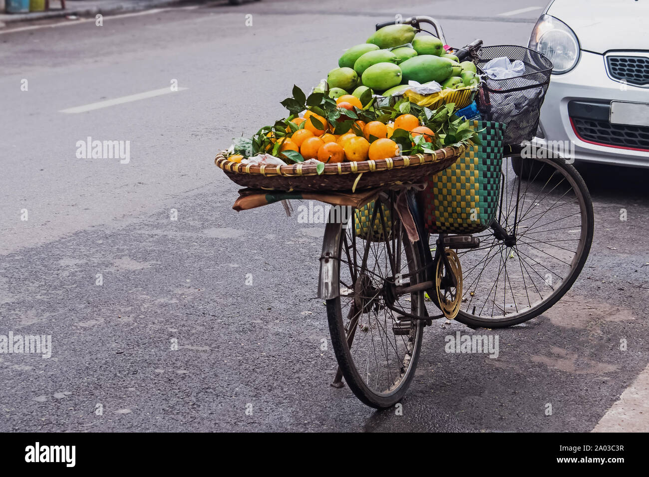 Fornitore di frutta in bicicletta sulla strada di Hanoi, Vietnam. Viaggio in Asia. Foto Stock