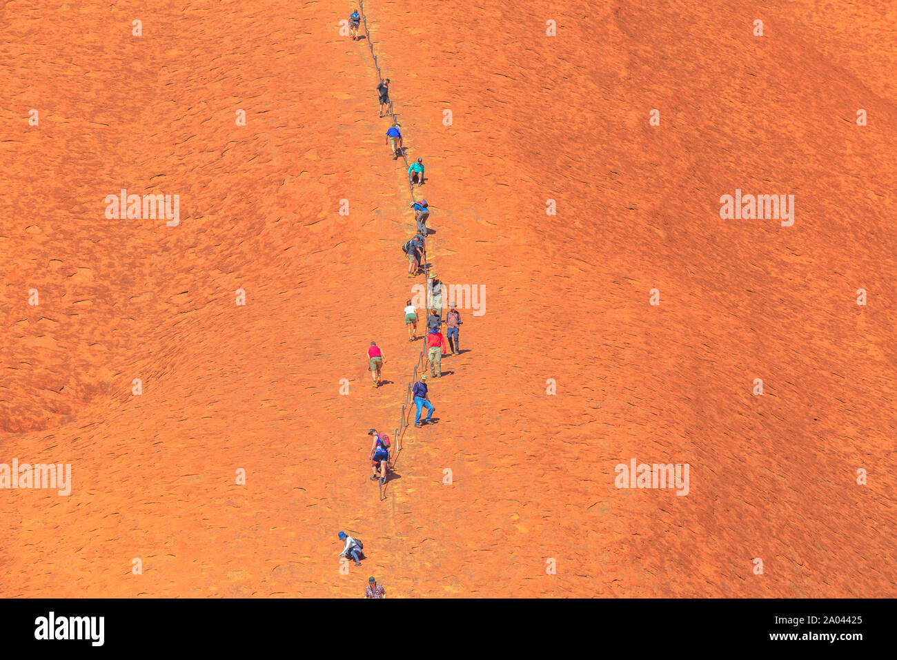 Uluru, Territorio del Nord, l'Australia - Agosto 23, 2019: closeup di persone salire su Ayers Rock. Climbing Uluru è sacro al popolo Anangu, il tradizionale Foto Stock