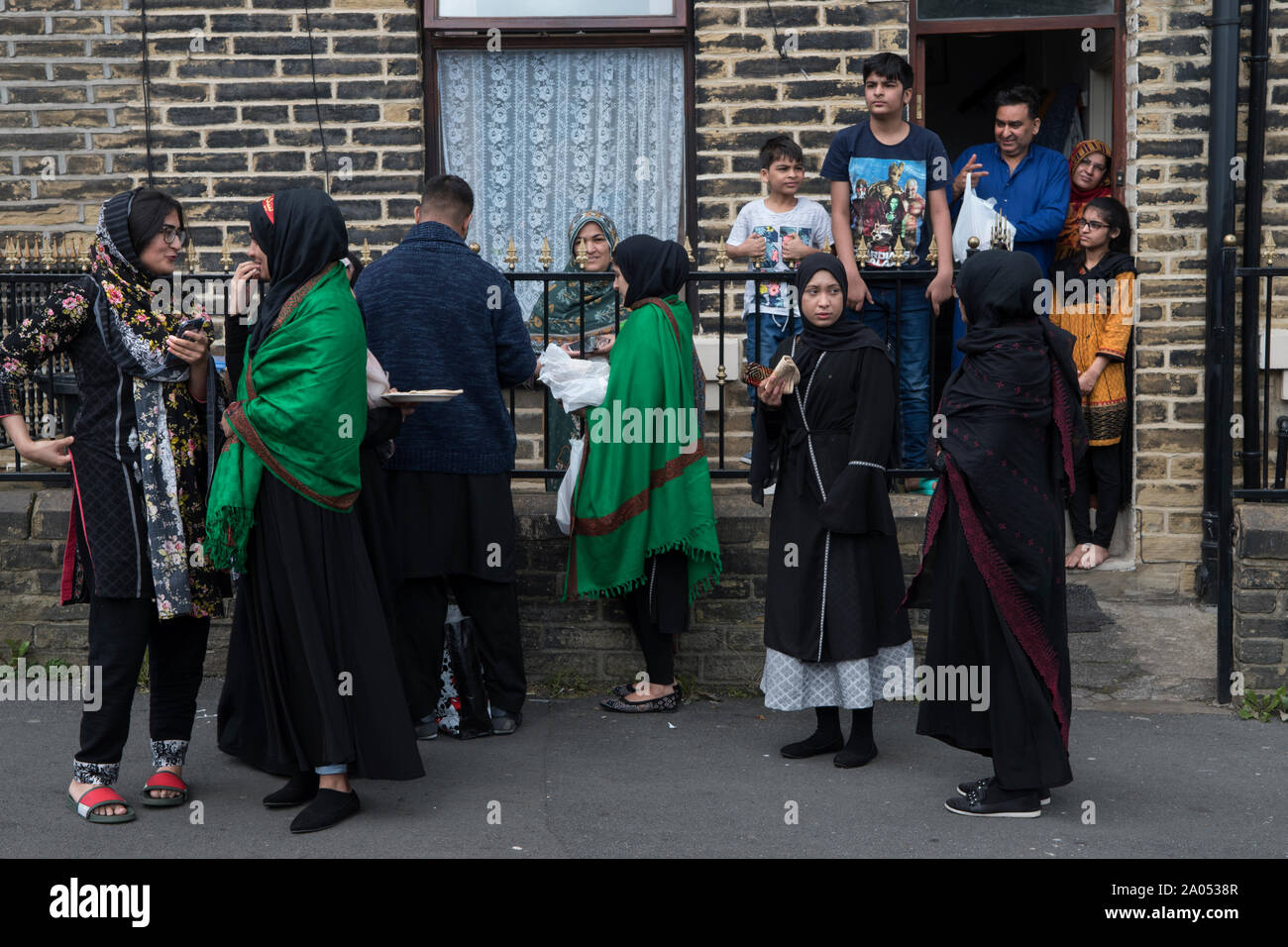 Comunità musulmana Bradford 2019, 2010s Regno Unito. Le famiglie al di fuori della loro casa, nel giorno della parata di Ashura, i musulmani sciiti ricordano il martirio di Hussain, ucciso nel deserto di Karbala nell'attuale Iraq nel 680 d.C. HOMER SYKES Foto Stock