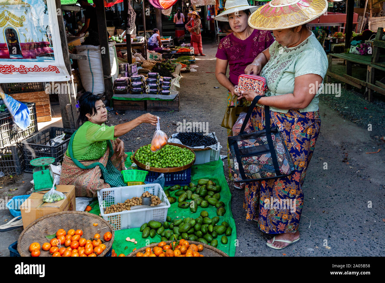 Donne locali l'acquisto e la vendita di frutta e verdura in mercato Mingalar, Nyaung Shwe, Lago Inle, Stato Shan, Myanmar. Foto Stock