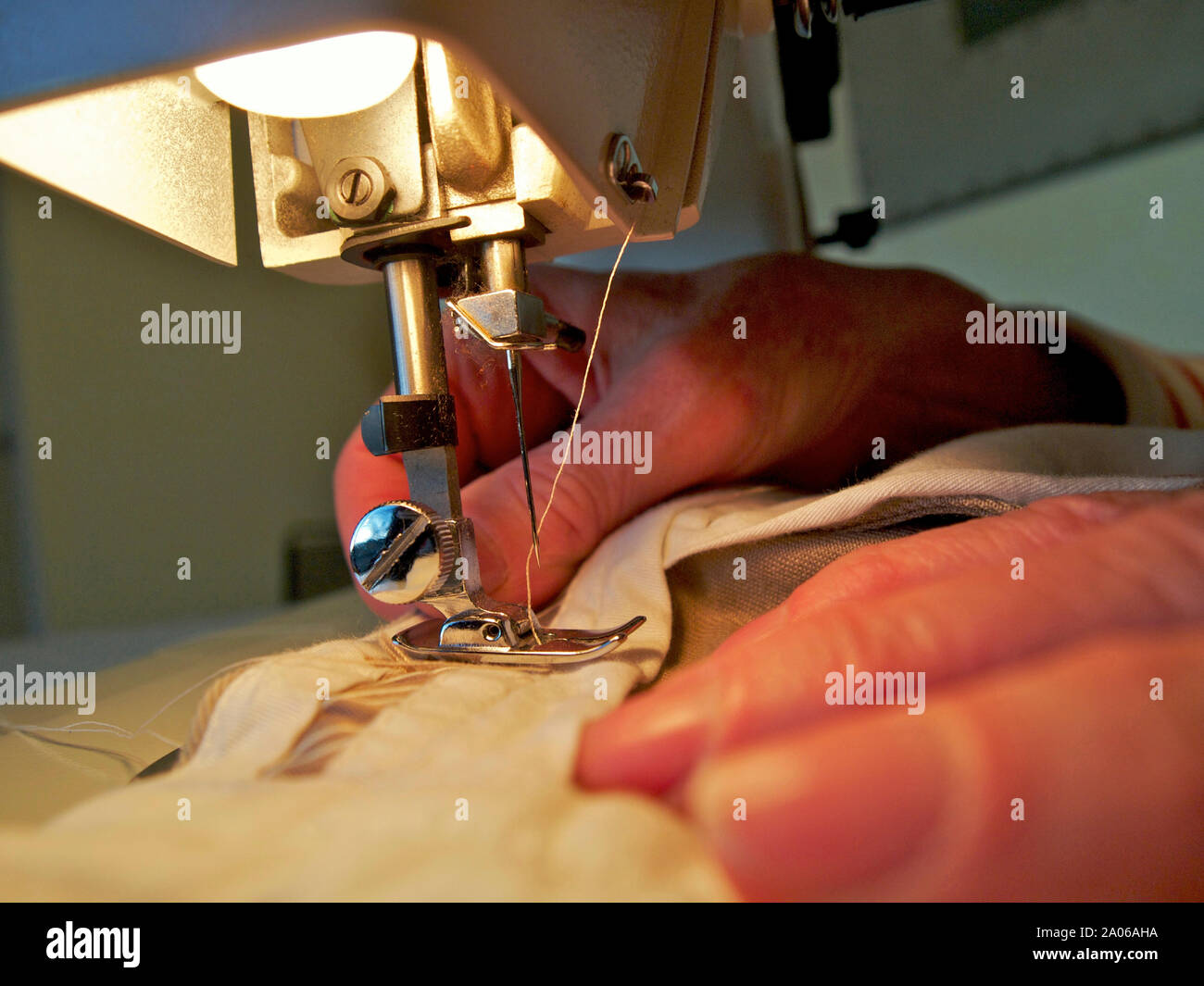 Mani di donna con una macchina da cucire Foto Stock