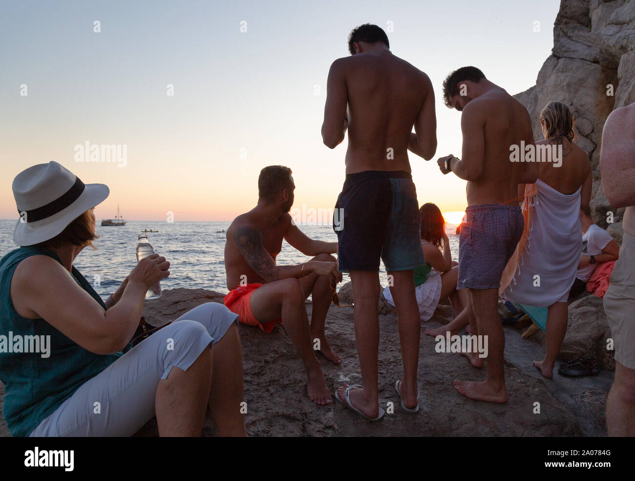 Le persone che bevono alla Buza bar e guardare il tramonto sul mare Adriatico, Dubrovnik Città Vecchia, Dubrovnik Croazia Europa Foto Stock