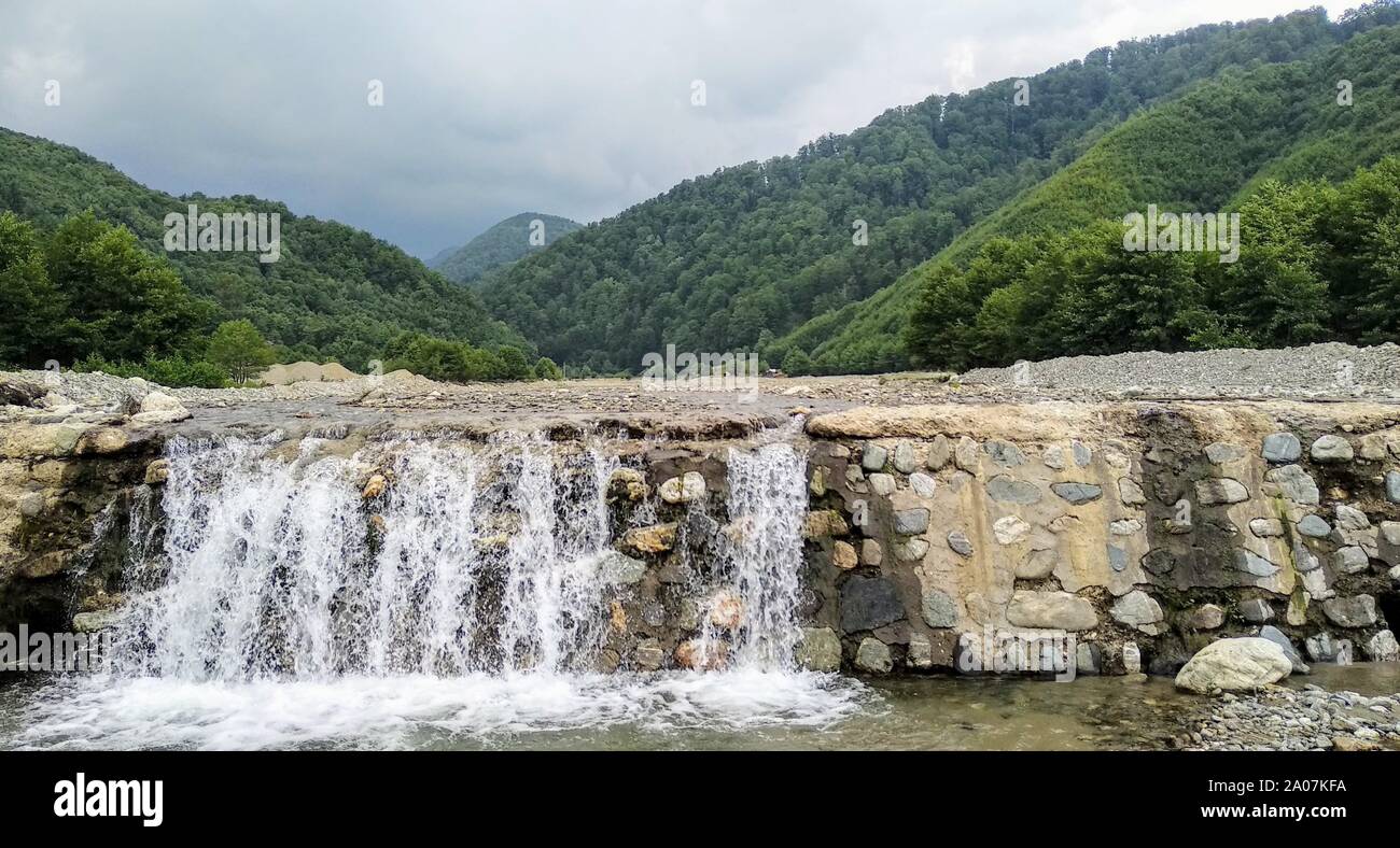 Immagine della natura con un piccolo fiume che corre attraverso le montagne boscose della Romania Foto Stock