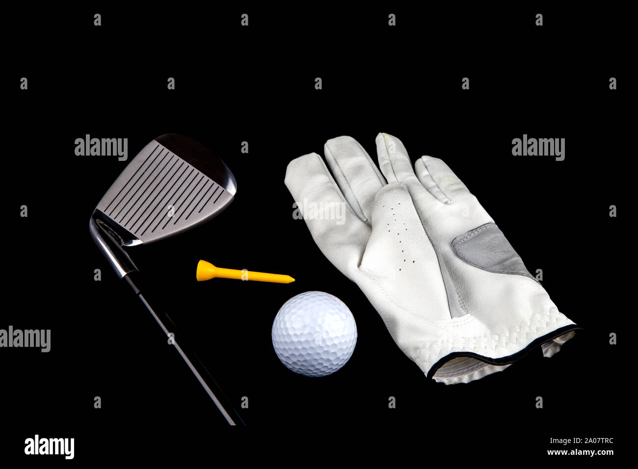 Golf club con guanto pallina e tee peg su sfondo nero Foto Stock