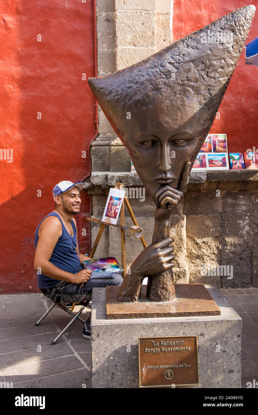 Artista del marciapiede accanto alla scultura artistica alla Galleria Sergio Bustamante, Tlaquepaque, vicino a Guadalajara, Jalisco, Messico. Foto Stock
