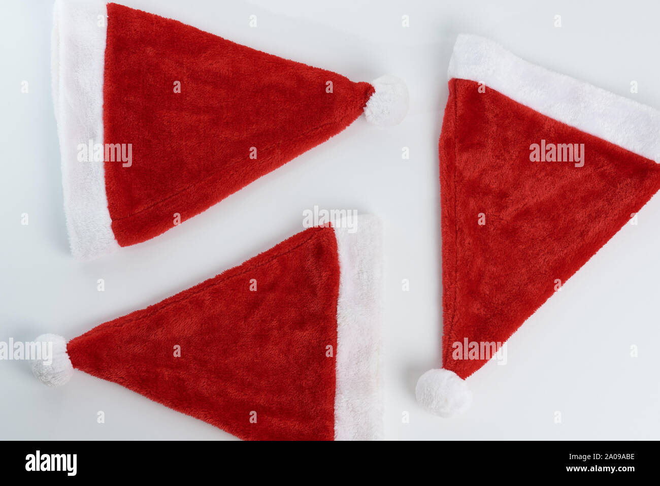 Cappelli di Natale sfondo. Santa Claus cappelli su sfondo bianco sopra visualizza Foto Stock