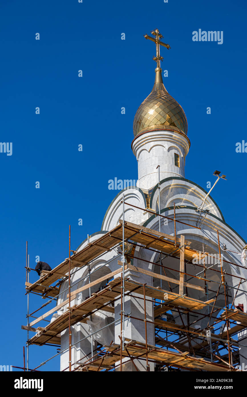 I costruttori sui ponteggi la costruzione della cattedrale di marittima posto accanto a Ulitsa Leningradskaya street a Petropavlovsk, Kamchatka, Russia. Foto Stock