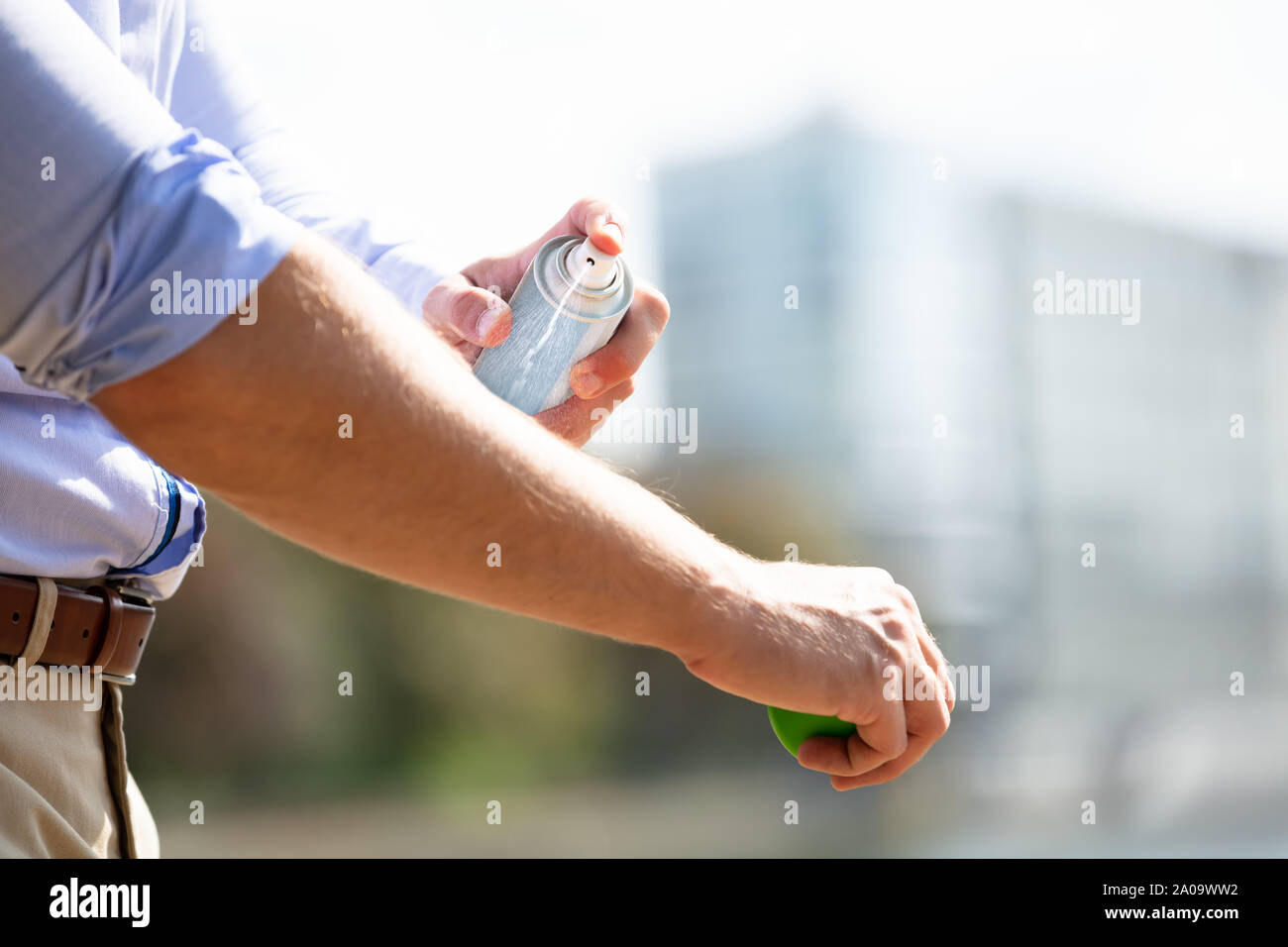 L'uomo la spruzzatura anti insetto Deet Spray sulla pelle sopra il suo braccio all'aperto Foto Stock