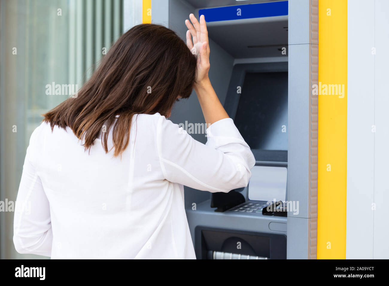 Close-up di deluso giovane donna che guarda la banca ATM macchina dopo la verifica del saldo del conto Foto Stock