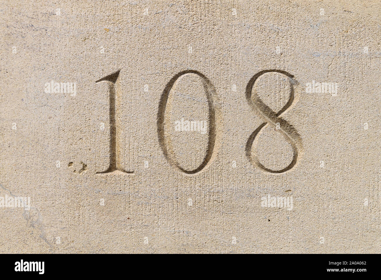 Numero 108 scavata nel calcare a parete a bugnato Foto Stock
