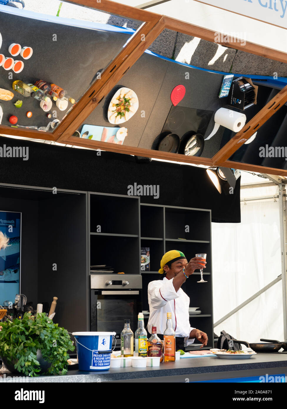La cucina di fusione chef Euton Lindsay dimostra al di sotto di un specchio di visione a Plymouth Seafood Festival 2019 Foto Stock