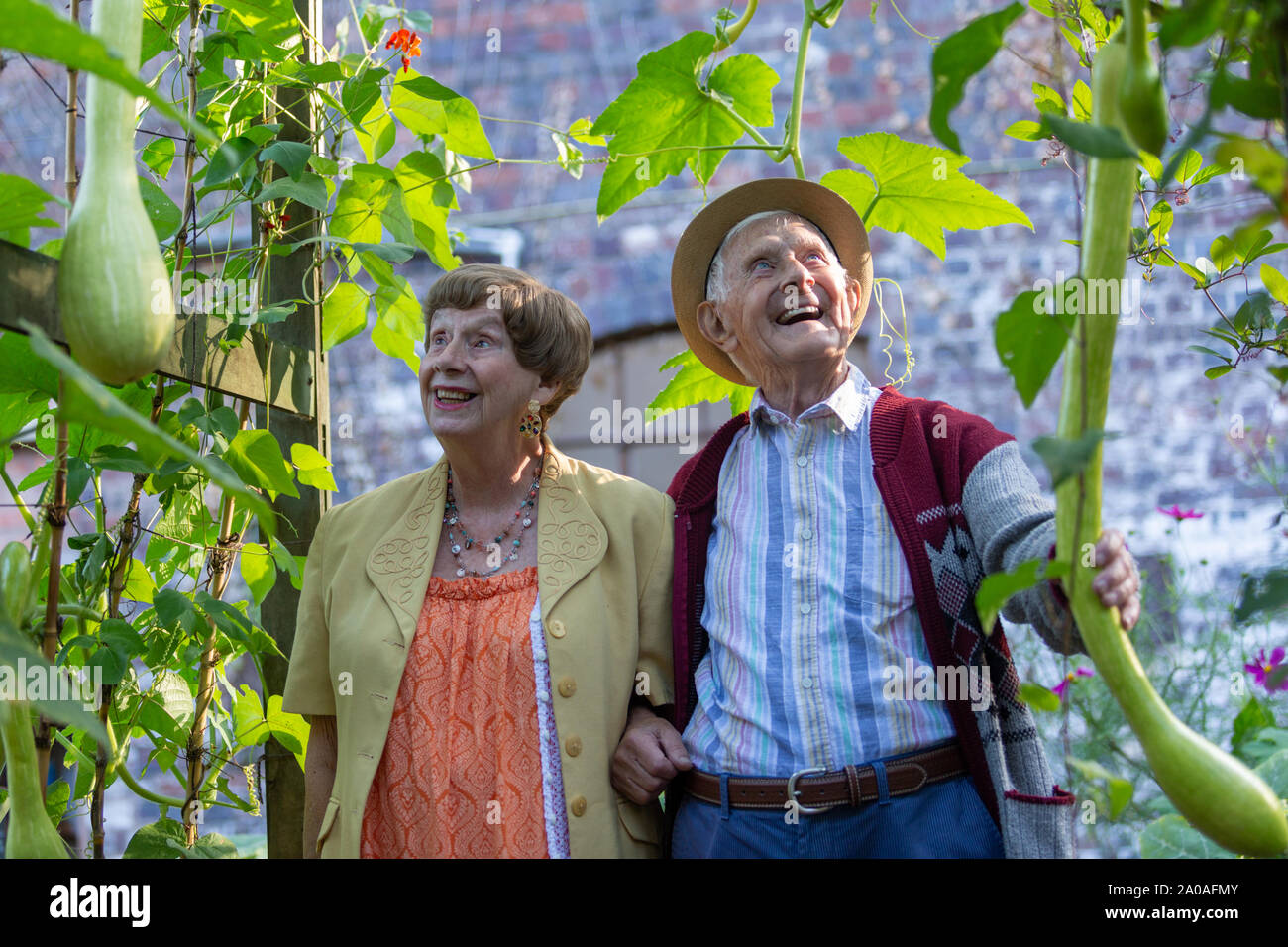 Due anziani godendo di un giardino sensoriale, con piante intorno a loro, REGNO UNITO Foto Stock