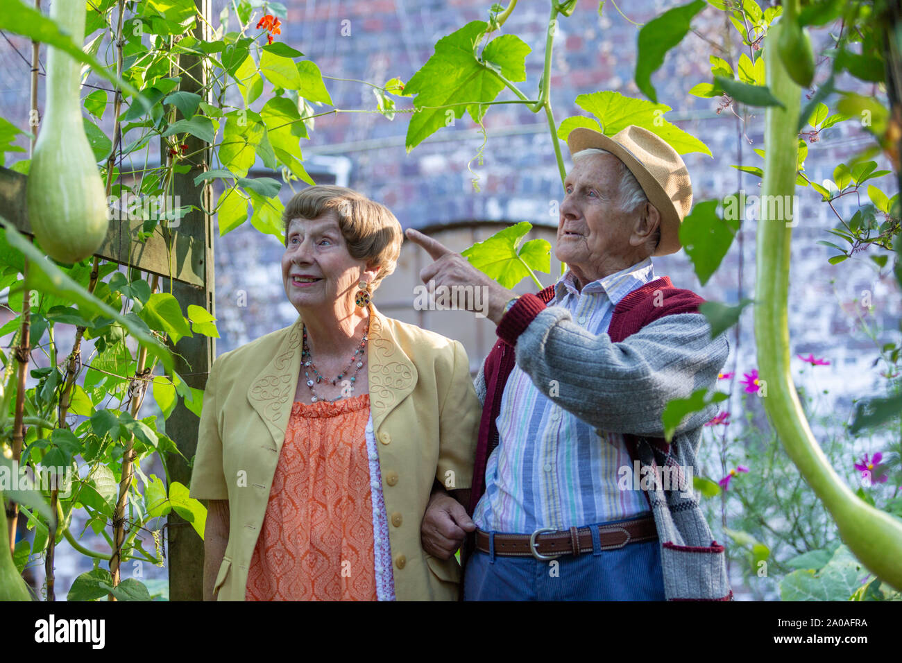Due anziani godendo di un giardino sensoriale, con piante intorno a loro, REGNO UNITO Foto Stock
