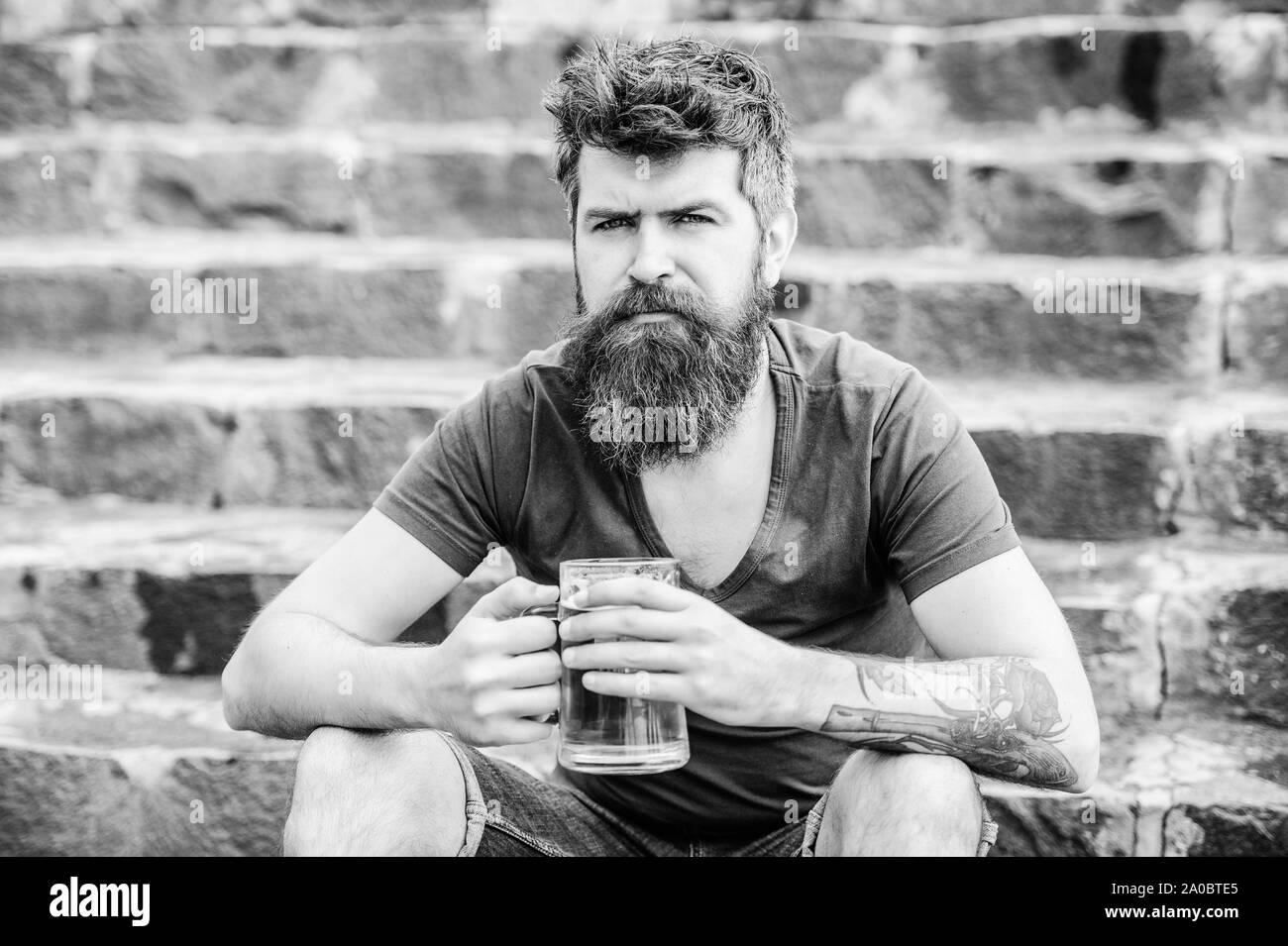 Bere birra alcolica bevanda. brutale maschio ha bisogno di ristoro. Coppia hipster con barba di bere birra. weekend relax. Uomo Barbuto con bicchiere di birra all'aperto. Il controllo di qualità di birra. Foto Stock