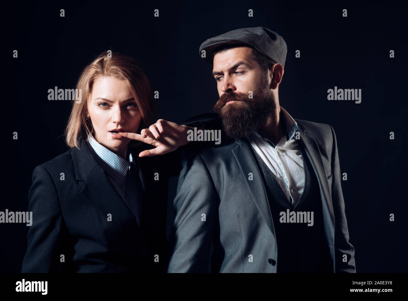 Coppia di detective o ricercatori, investigatori privati. L uomo e la donna in tuta retrò e hat su sfondo nero. Investigatore privato concetto. Cou Foto Stock