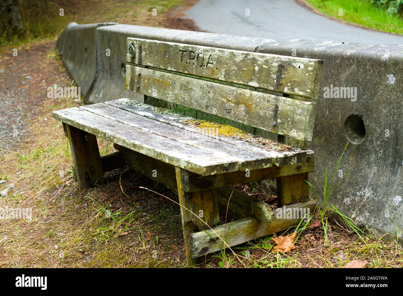 Una panca di legno su cui riposarsi dopo la salita dalla spiaggia a Chamvation Bay a Trincomali, North Pender Island, British Columbia, Canada Foto Stock