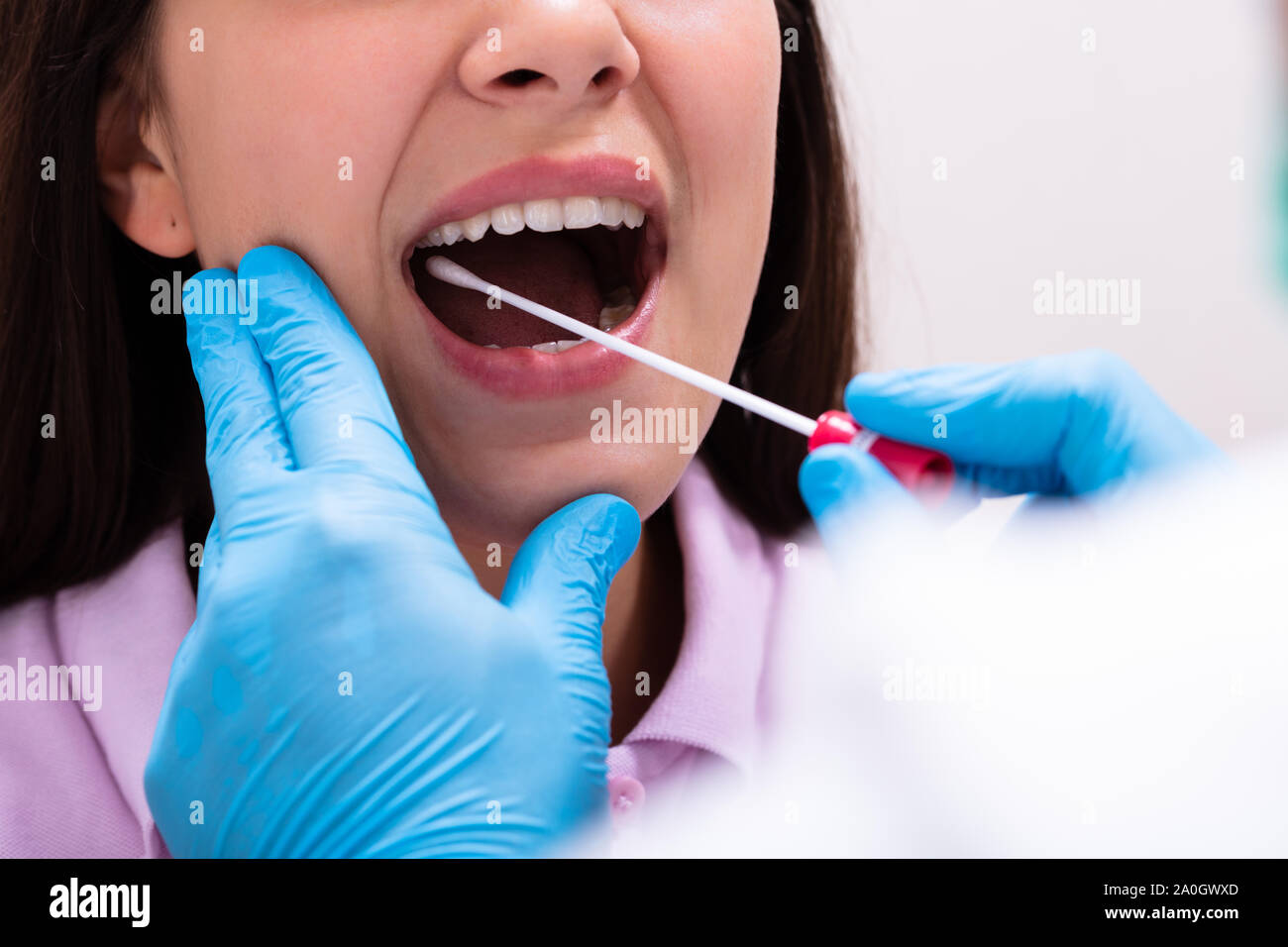 Vista posteriore di un medico di sesso maschile prendendo un fluido corporeo campione per il test del DNA Foto Stock