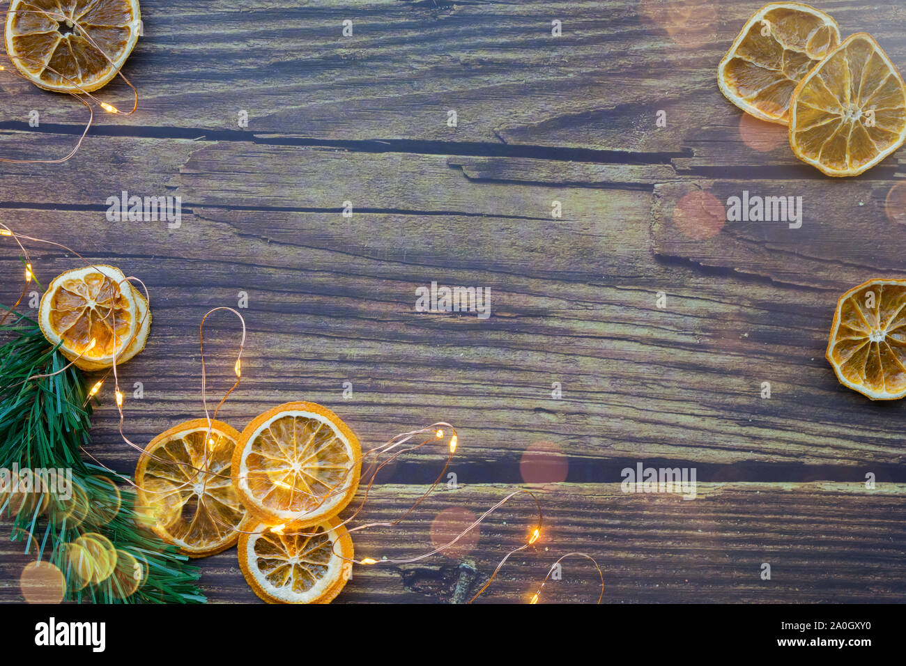 Sfondo di Natale da essiccato arance, ramoscello di pino e la ghirlanda su un tavolo di legno Foto Stock